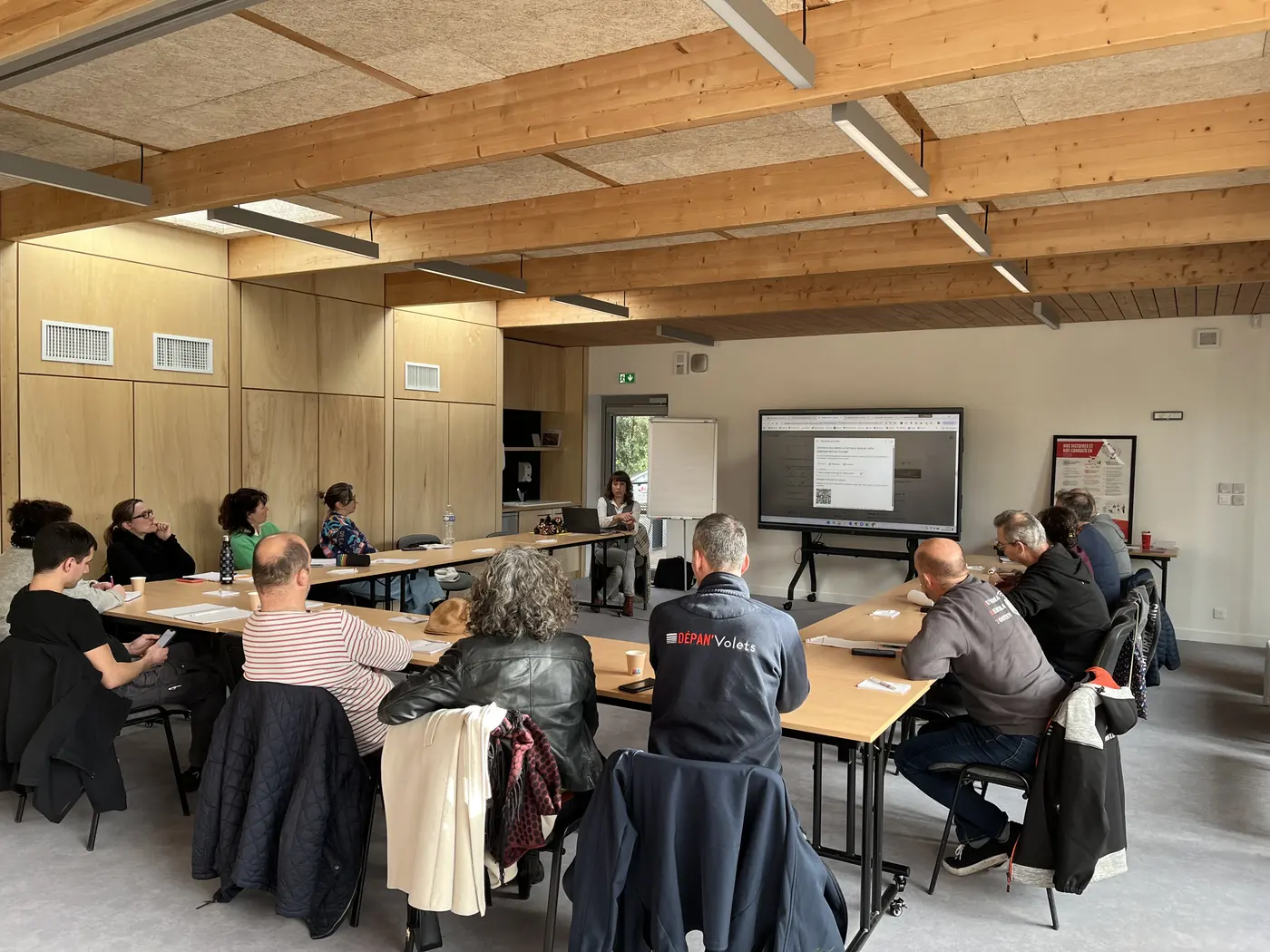 Participants installés autour des tables, en train de travailler sur leur fiche Google pendant l'atelier